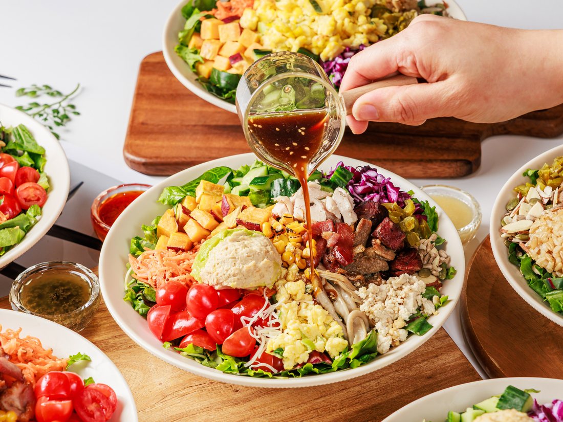 pouring dressing over a wellmixx bowl